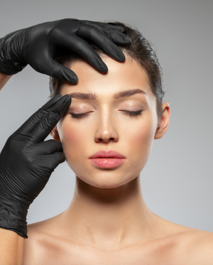 Imagen de una mujer con los ojos cerrados mientras unas manos enguantadas tocan su frente